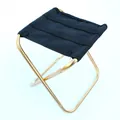Vista detallada de un taburete plegable portátil de aleación de aluminio dorado - Dorado