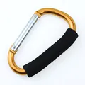 Detailaufnahme eines D-förmigen Aluminium-Karabiners mit weichem schwarzem Schaumstoffgriff - Gold