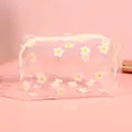 Gros plan d'une trousse à maquillage marguerite transparente et imperméable. - Petites fleurs blanches