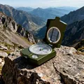 Detailed macro view of a professional green geological compass on a rugged mountain rock - Army Green