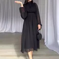 Detail of an elegant black midi dress with sheer mesh sleeves and a pleated waist. - XS / Dresses / Black
