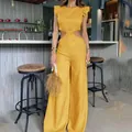 Detail view of yellow wide-leg jumpsuit with ruffle sleeves and waist cutouts - S / Dresses / Yellow