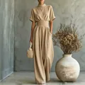 Detail view of a beige high-neck short-sleeve wide-leg jumpsuit with belted waist - S / Set / Khaki