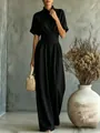 Elegant black high neck jumpsuit with short sleeves and wide legs, styled with a woven bag. - S / Set / Black