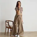 Full-length view of chic tan tie-waist wide-leg skirt-pants on a stylish female model. - XS / Bottoms / Khaki