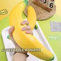 Grand jouet squishy banane jaune pour soulager le stress présenté dans une main - Squishy Banane (T33) / 40CM Extra Large