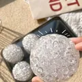 Gros plan d'une balle anti-stress texturée translucide avec une surface à bulles - Style Clair de lune Blanc / Blanc Clair