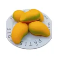 Vista macro de juguetes antiestrés realistas con forma de mango en un plato blanco - Estilo de Mango de Simulación