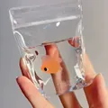 Gros plan d'un mignon poisson rouge dans un sac d'eau transparent jouet à presser - Sac de Poisson Rouge / 12x8cm