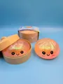 Dettaglio di un giocattolo squishy a forma di panino glitterato con faccina e cestino - Arancione Glitter Dorato