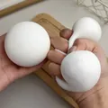 Dettaglio di un giocattolo antistress a forma di panino bianco mostrato mentre viene schiacciato - Pane al Vapore Grande Malleabile / 6cm
