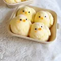 Detailed macro shot of four fuzzy yellow chick squishy toys resting in a paper tray - Plush Big Chicken (Set of 4)