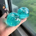 Close-up of a translucent turquoise apple squishy toy with sparkling ocean shell glitter - Ocean Shell Apple Style / Blue Shell