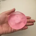 Balle de jouet anti-stress spongieuse rose semi-transparente faite à la main tenue en main - Balle à la Main en Vaseline Rose