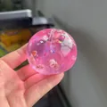 Macro detail of a pink transparent apple squishy toy containing shells and sparkling glitter stars - Pink Shell