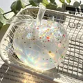 Close-up of a pearlescent glitter-filled apple squishy toy in a wire basket - Christmas Snowman Vaseline Apple