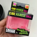 Gros plan d'un jouet balle antistress rose en forme de cube dans son emballage noir - Glaçon Rose 5cm