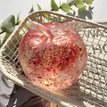 Detailed macro shot of a clear glitter-filled apple squishy stress relief toy. - Christmas Santa Vaseline Apple