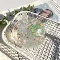 Transparante appelvormige squishy met kleurrijke glitters in een wit mandje - Kerstboom Vaseline Appel / Transparante Kleurrijke Pailletten