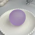 Pallina antistress viola satinata fatta a mano presentata su un piatto bianco decorato - Viola Opaco