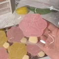 Close-up of pink cat paw popsicle squishy toy with sugar-like texture in clear bag - Pink
