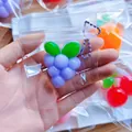 Detail of a purple grape-shaped TPR squeeze toy in a clear mini bag with a ball chain - Mini Grape / PVC Bag + Chain
