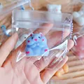 Close-up of a blue hamster squishy toy in a clear mini bag with a purple bead chain hanger - Blue
