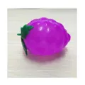 Juguete antiestrés con forma de uva morada sobre madera - Uva Squishy