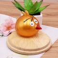 Juguete antiestrés con forma de pájaro dorado para descompresión sobre base de madera - Squishy Angry Bird