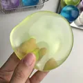 Main tenant une balle anti-stress jaune-vert translucide pour le soulagement du stress - Style Vert Haute Transparence / 6cm