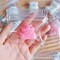 Detail view of a mini pink hamster squishy stress relief keychain toy in a bag - Pink