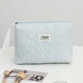 Vista detallada del neceser azul acolchado con corazones y etiqueta de marca. - M / Bolso Nube Corazón Azul