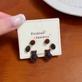 Hand-held set of cute brown plush bear stud earrings with scarf details and coffee beans. - Coffee Bean Ball Bear Earring Set