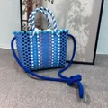 Close-up of a colorful woven bucket bag with blue rope shoulder strap detail - Sky Blue