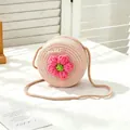 Detailed view of a pink round straw crossbody bag for girls with a cute crochet flower. - SWEET Pink Flower / Pink