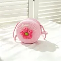Close-up detail of a pink straw woven round bag with a flower and Sweet emblem - SWEET Pink Flower / Light Pink