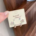 Élégant ensemble de boucles d'oreilles fleurs vert menthe et nœuds argentés sur carte - Papillon Vert Fleur Cinq Pétales