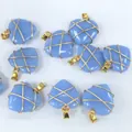 Detalle de los colgantes de corazón de piedra azul envueltos con alambre de cobre oro - Azul Luminoso