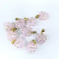 Primer plano de colgantes de cristal rosa en forma de corazón con hilo dorado envuelto - Rosa Jade