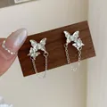 Elegant silver butterfly tassel earrings with sparkling cubic zirconia on a wooden display - White Zircon Double Butterfly Earrings