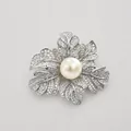 Detailed macro view of an elegant rose flower brooch with crystals and a large center pearl - Silver-White Pearl Rose