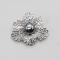 Close-up detail of an elegant silver rose leaf brooch featuring a dark pearl and pavé crystals. - Silver-Grey Pearl Rose