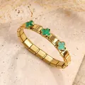 Elegante pulsera elástica de acero inoxidable dorado con tres dijes de trébol verde - Estilo de Trébol con Concha Verde / Dorado