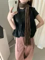 Dettaglio di un gilet in pelle nera vintage con una lunga sciarpa marrone. - M/Taglia Unica / Top / Nero