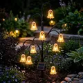 Detailed view of Halloween solar tree lights with glowing ghost lanterns in a garden night - Ghost