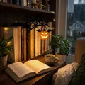 Lanterna a zucca di Halloween appesa a una libreria scura con una calda luce soffusa - Zucca / Arancione