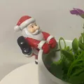Detailansicht einer niedlichen Weihnachtsmann-Figur aus Harz an einem weißen Blumentopf - Weihnachtsmann-Stil