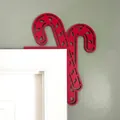 Detail showing a red wooden candy cane ornament placed on a white door frame corner. - Candy Cane / Red