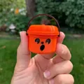 Hand hält einen mini orangefarbenen Halloween-Kürbiseimer mit Überraschungsgesicht. - Überraschter Ausdruck / Orange B