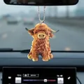 Detailed macro view of the fluffy Highland Cow car pendant on a rearview mirror - Highland Cow